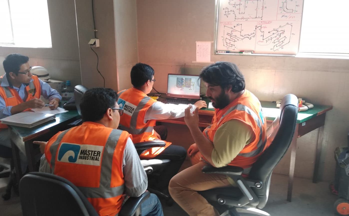 Equipo de Master Industrial revisando planos de un proyecto